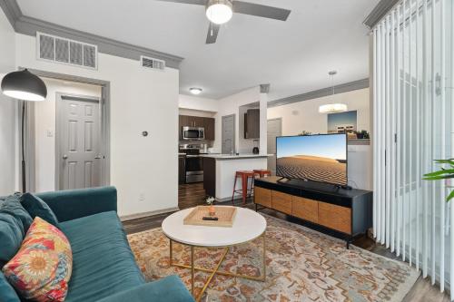 a living room with a couch and a tv at Furnished apartments next to the Domain in Austin