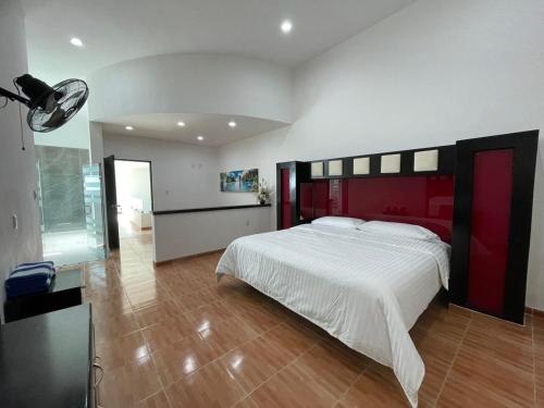 a bedroom with a large bed with a red headboard at Hotel Casa Bendicion in Los Limones