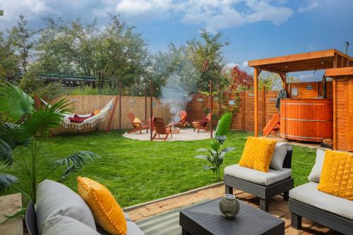 ein Garten mit Hängematte und ein Hinterhof mit Feuerstelle in der Unterkunft Cozy - Private Hot Tub & Garden - Fire Pit - Pet Friendly in Hajdúszoboszló