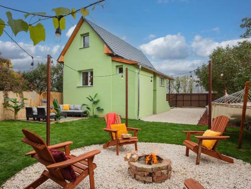 einen Hinterhof mit Schaukelstühlen und einer Feuerstelle in der Unterkunft Cozy - Private Hot Tub & Garden - Fire Pit - Pet Friendly in Hajdúszoboszló