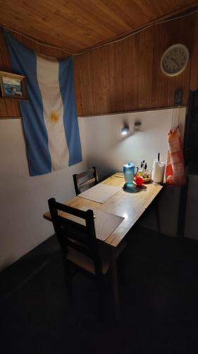 una mesa de madera en una habitación con un reloj en la pared en 100 años ciprés, en Río Gallegos