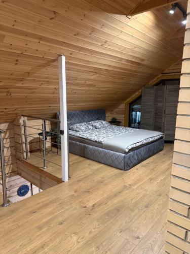a bed in a room with a wooden ceiling at Pirtiņa in Zeltiņi