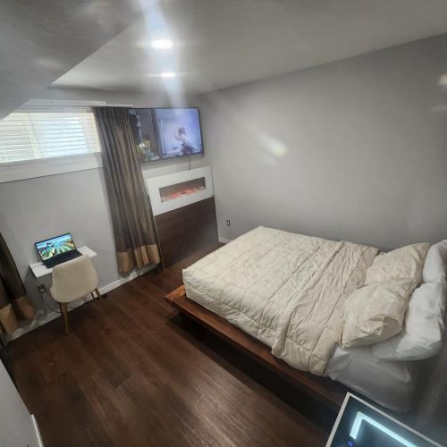 a bedroom with a bed and a tv on the wall at beautiful private house in Edmonton