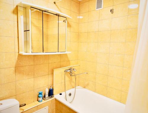 a bathroom with a tub and a sink at M&M Apartment V SELF CHECK-IN in Panevėžys