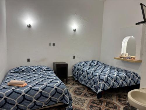 a bedroom with two beds and a sink at Habitaciones Climar in Veracruz