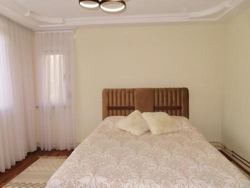a bedroom with a bed with two pillows on it at Chez Apartment in Prizren