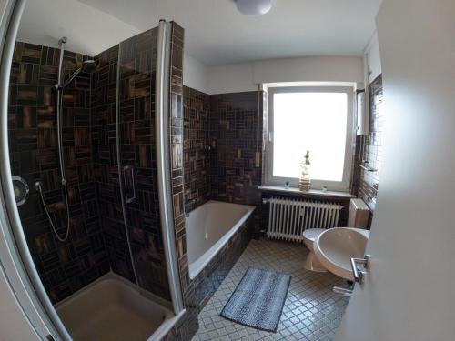 een badkamer met een bad, een toilet en een wastafel bij Moderne Zimmer in Steinhagen mit Balkon in Steinhagen