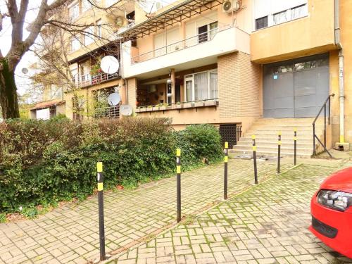a red car parked in front of a building at Chez Apartment in Prizren