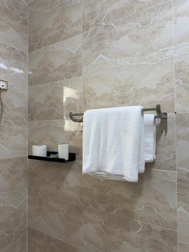 a bathroom with white towels hanging on a wall at نزل الصيف للشقق المخدومة in Al Namas