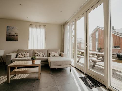 a living room with a couch and a large window at Waterside Escape with Easy Access in Uitgeest