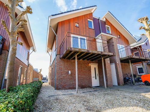 an apartment building with two balconies on a street at Waterside Escape with Easy Access in Uitgeest