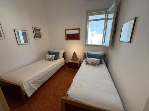 two twin beds in a room with a window at villa De Simone in Campomarino