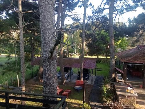 a tree house with a hammock in a yard at Casita de Arena Cabaña 1 in Mar de Ajó
