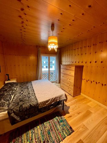 a bedroom with a bed in a wooden room at Pragma Apartments - Appartamento Arcade in Predazzo