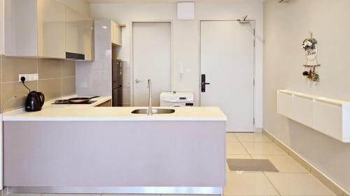 a kitchen with white cabinets and a sink at Trion Sky Suite KL in Kuala Lumpur