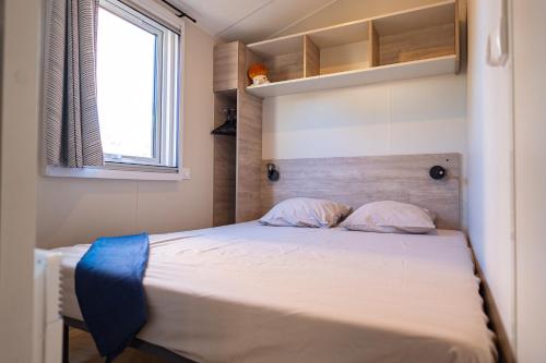 バラリュック・レ・バンにあるCamping Mas du Padreのベッド1台(枕2つ付)、窓が備わる客室です。