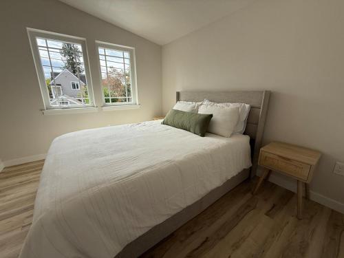 a bedroom with a large bed and two windows at North Slope Nest in Tacoma
