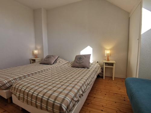 dos camas en una habitación pequeña con dos lámparas en Maison dans résidence mer - piscine, en Loc-Maria-Plouzané