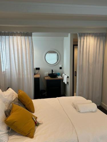 a bedroom with a large white bed with yellow pillows at 'het Haasje' in Hedel