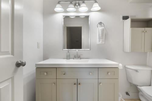 ein weißes Badezimmer mit Waschbecken und Spiegel in der Unterkunft King Beds Full Kitchen Peaceful 2br Casita Re in Washington