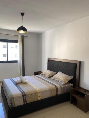 Un dormitorio con una cama grande con una ventana grande. en Appartement lumineux à 5 minutes de la gare, en Casablanca