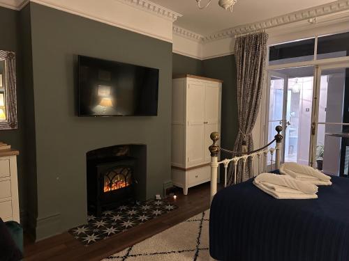 a bedroom with a fireplace and a tv on the wall at The Garden Flat - Newly Refurbished Throughout in Dorchester