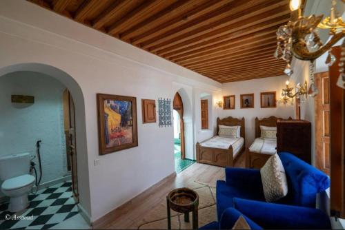 a living room with a blue couch and a bedroom at Dar Chama in Chefchaouene