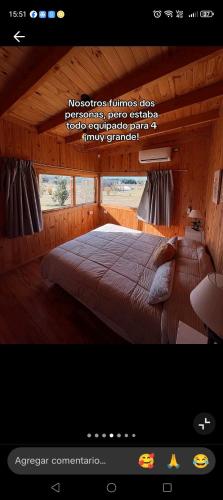 Un dormitorio con una cama grande en una habitación de madera. en Lara cabañas, en Guaymallén