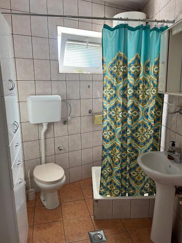 a bathroom with a toilet and a shower curtain at River apartman Paraćin in Paraćin