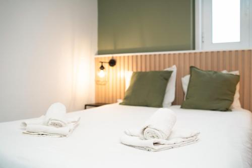 a bedroom with a white bed with towels on it at Porto Panorama by Sira Stays in Porto