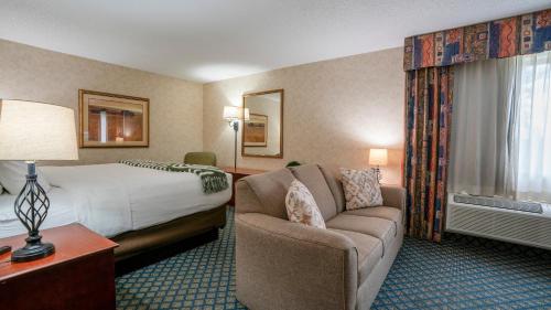 a hotel room with a bed and a couch at Miles City Hotel & Suites in Miles City