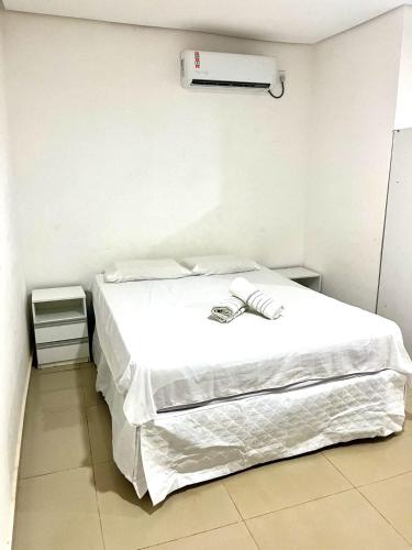 a white bed in a white room with avertisementvertisement at Carolina Palace HOTEL in Carolina
