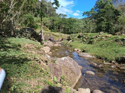 una corriente de agua con rocas en un campo en Sítio Toca da Onça- Lumiar, en Nova Friburgo