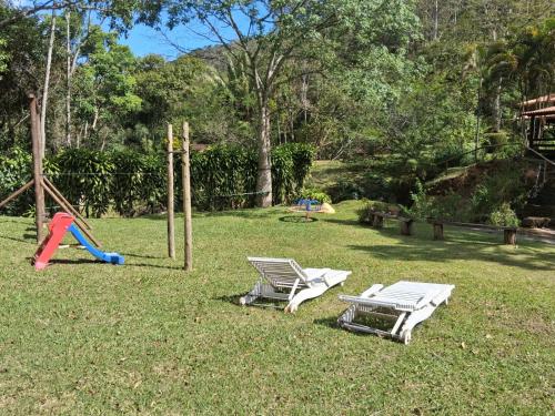 2 tumbonas y un patio con parque infantil en Sítio Toca da Onça- Lumiar, en Nova Friburgo
