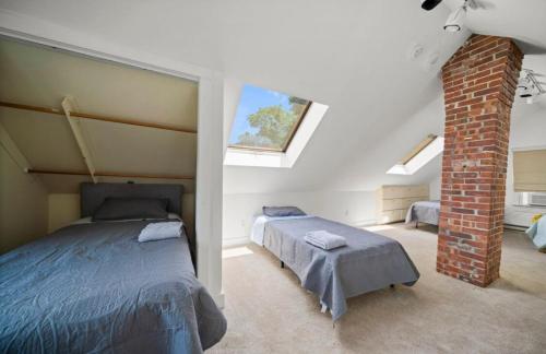 Un dormitorio con dos camas y una pared de ladrillo. en Casa de campo para días inolvidables!, en Danbury