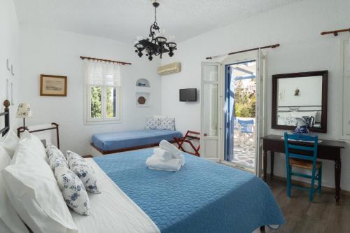 a bedroom with a bed with a blue comforter at Saint Louis in Andros