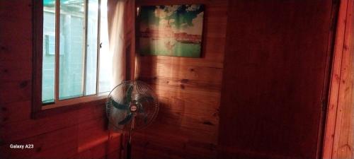 a fan in a room next to a window at recanto de pepe 1 in Santa Vitória do Palmar