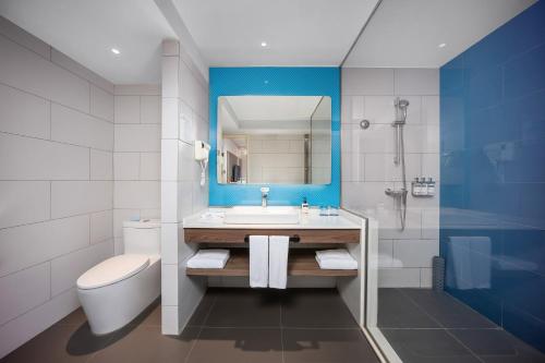 西安西安钟楼智选假日酒店的带水槽、马桶和镜子的浴室