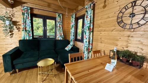 a living room with a green couch and a clock at Osada Międzywodzie in Międzywodzie