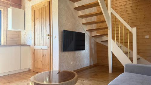 a living room with a tv and a staircase at Osada Międzywodzie in Międzywodzie