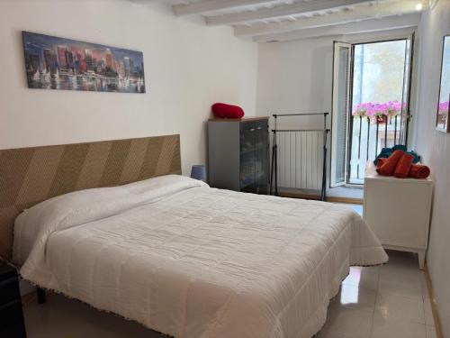 Bassano RomanoにあるCasa Yogaの白いベッドと窓のある寝室