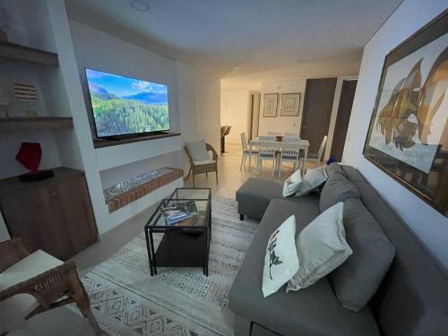 a living room with a couch and a flat screen tv at Exclusivo apartamento con vista al lago Sochagota in Paipa
