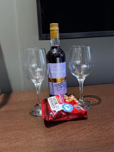 a bottle of wine and two wine glasses on a table at Brown Velvet Thess in Thessaloniki