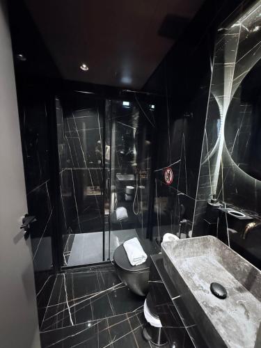 a black bathroom with a toilet and a shower at Brown Velvet Thess in Thessaloniki
