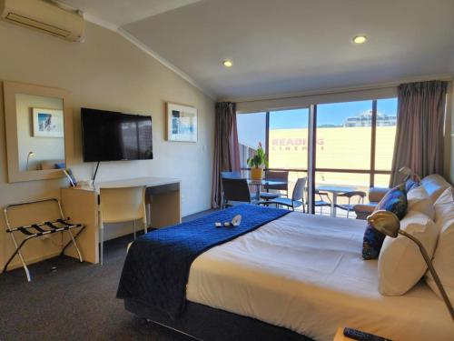 a hotel room with a bed and a desk and a television at U Residence Hotel, Signature Collection by BW in Wellington