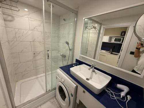 ein Badezimmer mit Waschbecken, Dusche und Spiegel in der Unterkunft Premium Sea Horizon Orbi City in Angisa