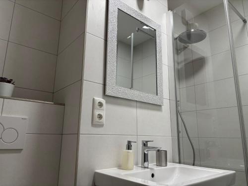 a white bathroom with a sink and a mirror at Ferienwohnung Held in Obertraun