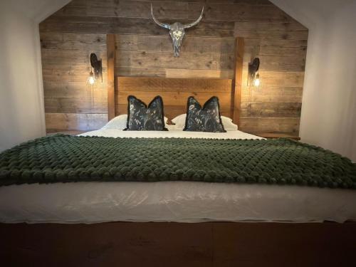 ein Schlafzimmer mit einem Bett mit einem Stierkopf an der Wand in der Unterkunft Blackwood - Peaceful cottage surround by woodlands in Byfleet