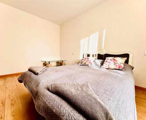 a bedroom with a bed with a blanket and pillows at M&M Apartment VI SELF CHECK-IN in Panevėžys