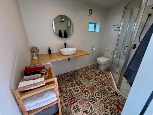 a bathroom with a sink and a mirror at Brighton Beach in Dunedin